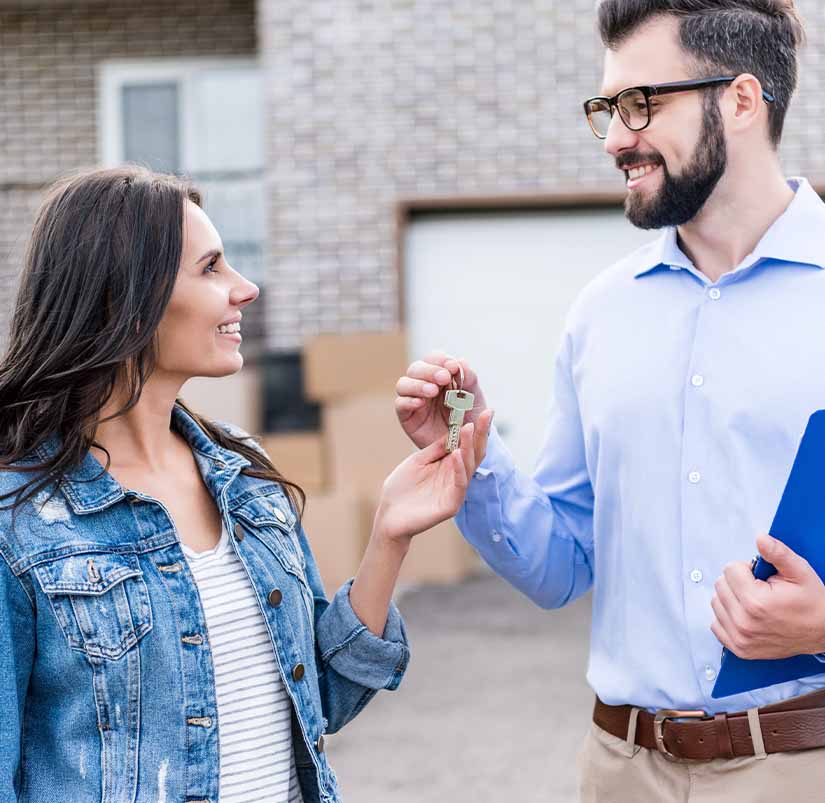 client and professional with a key to new property after a property title search in Fayetteville, AR