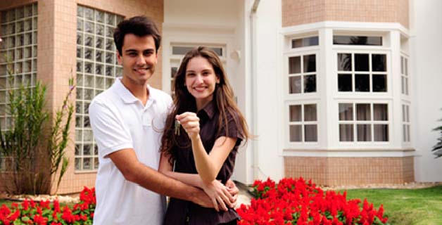 Couple in front of new home after doing a property title search in Bentonville, AR